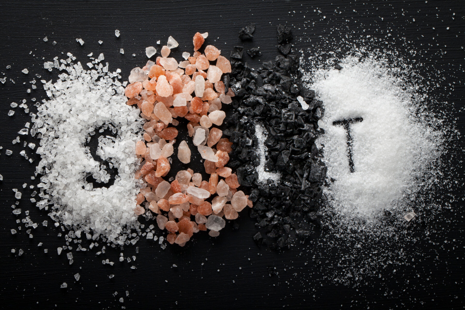 collection of different types of salt on black background